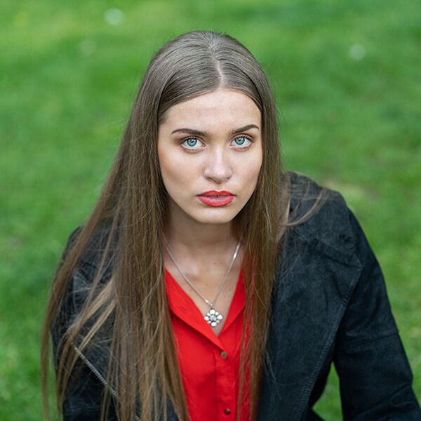 An outdoor editorial portrait of a woman wearing red