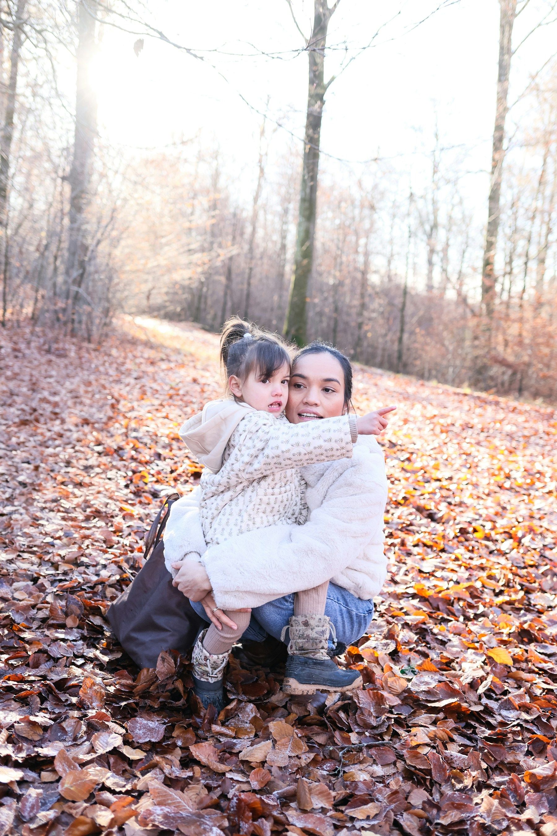 A mother and child sharing a quiet moment in woodland